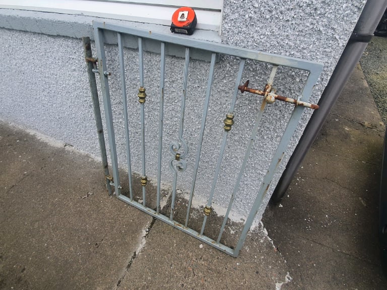 Wrought iron garden gate with wall hanging bar