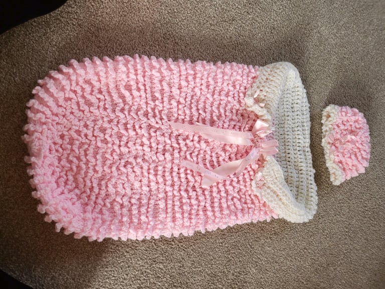 Pink and white knitted sleeping bag and hat