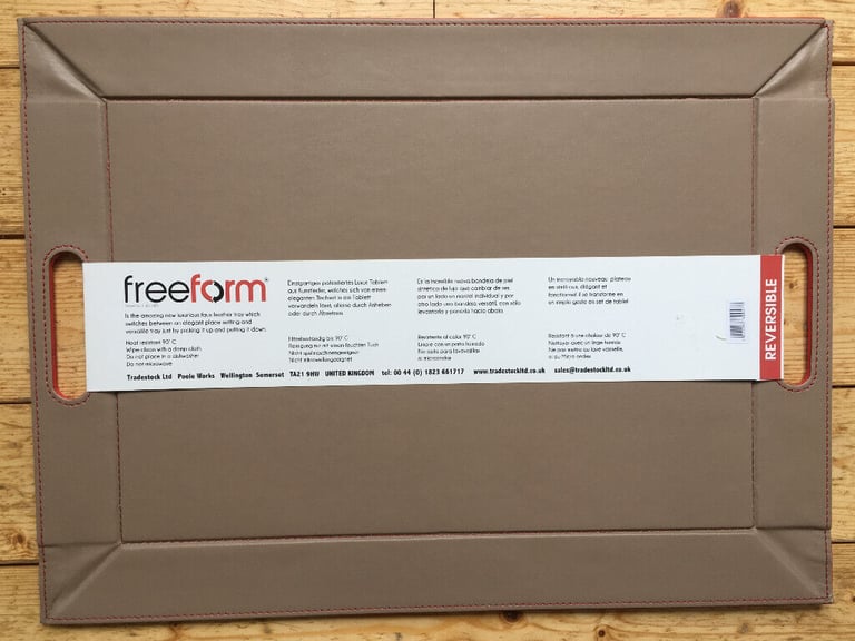 	Unused reversible red/beige freeform faux leather tray/placemat.Original packaging. £12 ovno.