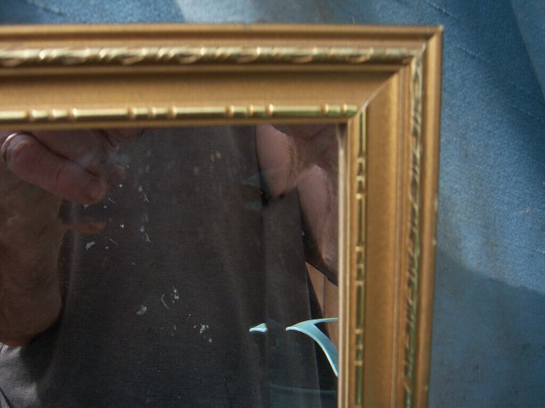 Gold mirror with bevelled plate.