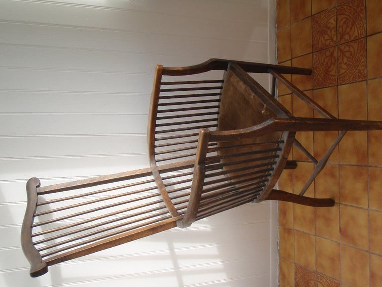 Antique High spindleback chair with matching armrests and padded seat.