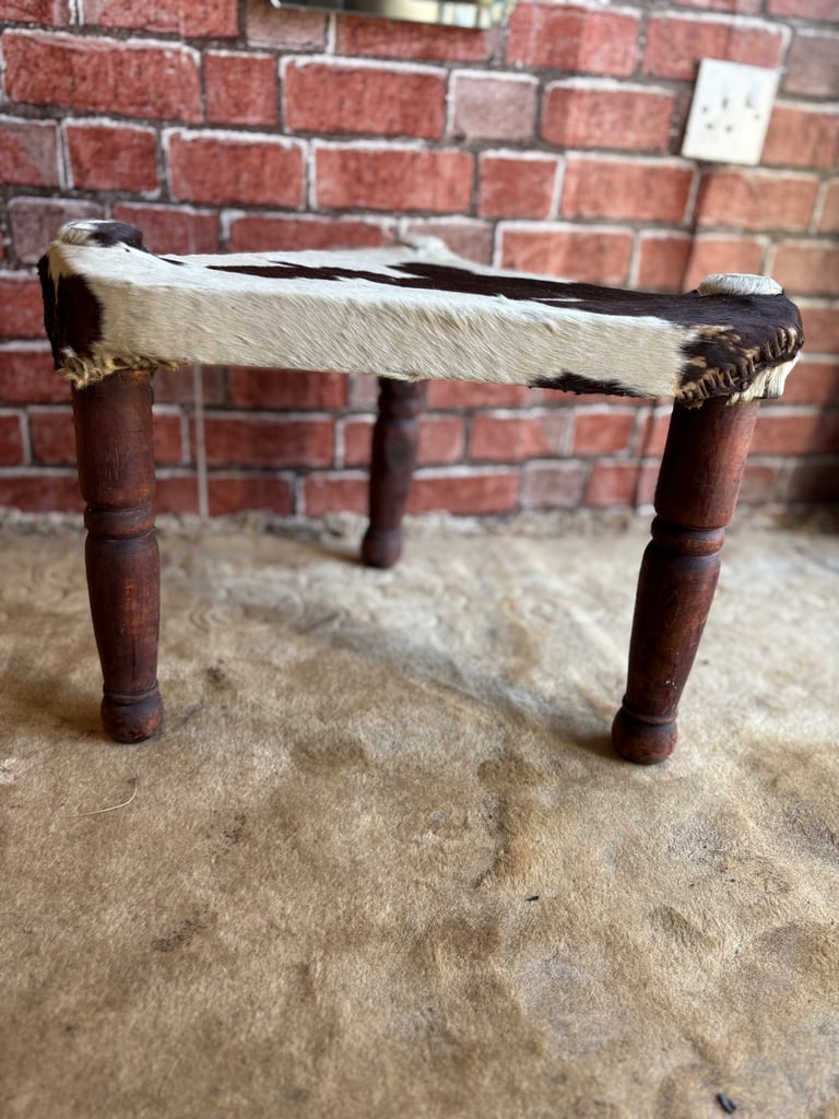 A Vintage Handmade 3 legged stool with cow hide seat.