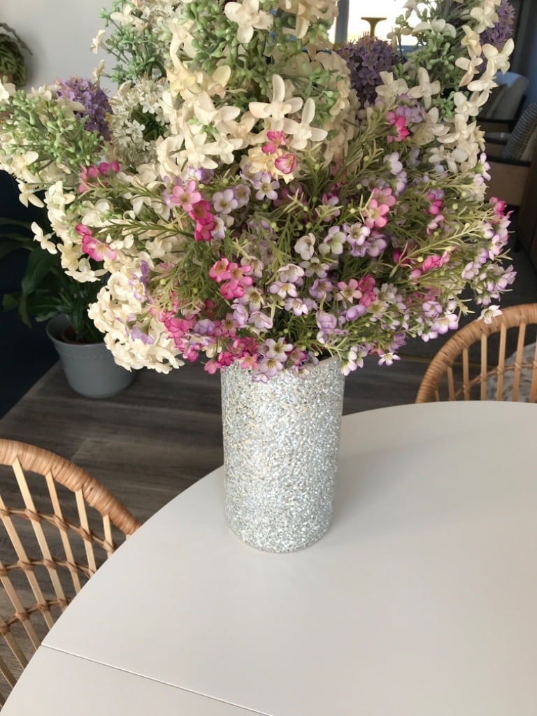 Glitter vase with large display of artifical flowers