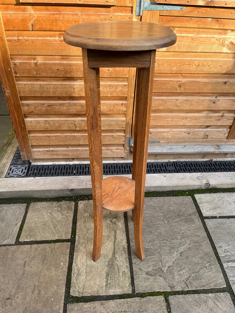 image for A four legged oak plant stand with round top.