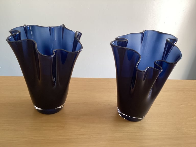A pair of blue glass flower vases. 