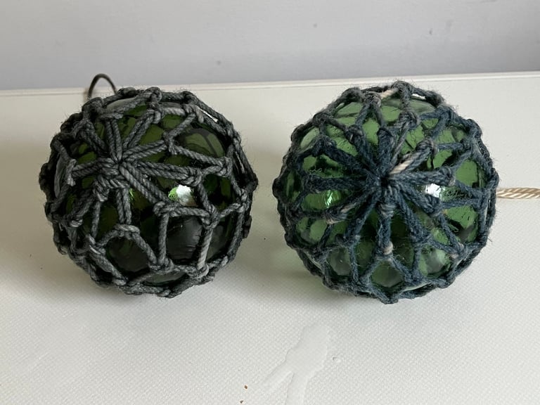 2 vintage green glass fishing floats in original string netting