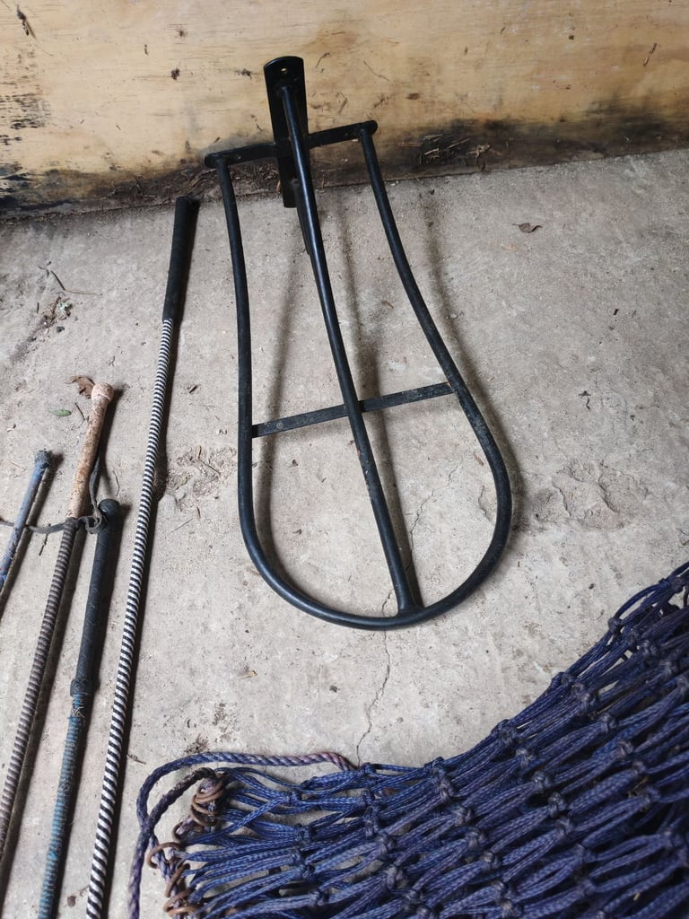 Saddle rack, two hay nets, lunge whip, riding crops
