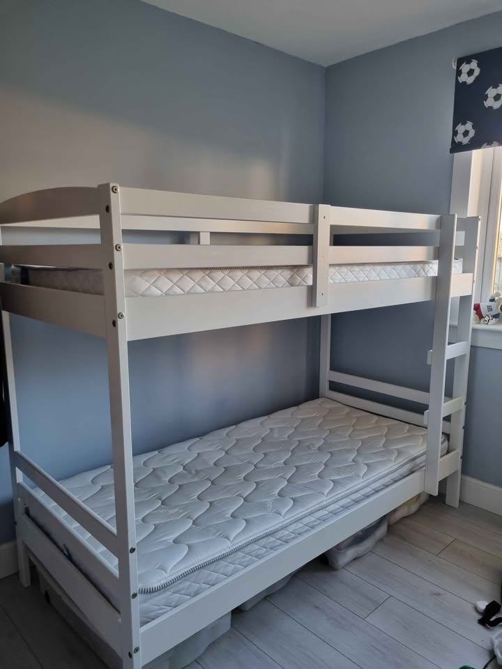 White wooden framed bunk beds with mattresses