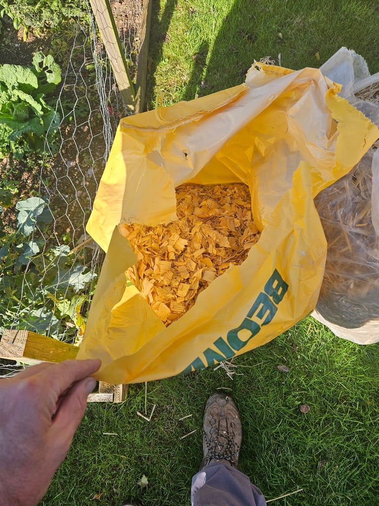 Wrapped bail of straw and course wood chippings chicken bedding 