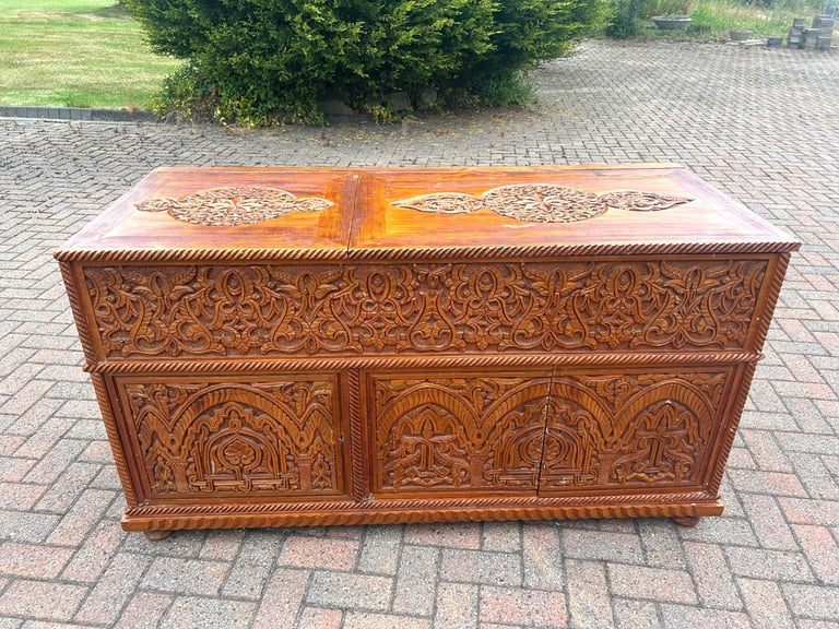 image for A HEAVILY CARVED AND STAINED STORAGE CHEST OR TV CABINET 147 CM X 62 CM X 80 CM.