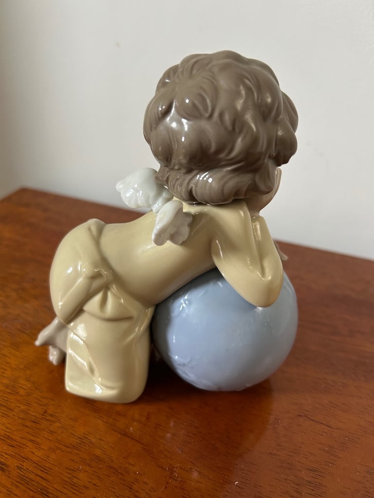 NAO by Lladro girl angel, leaning over a globe with bird