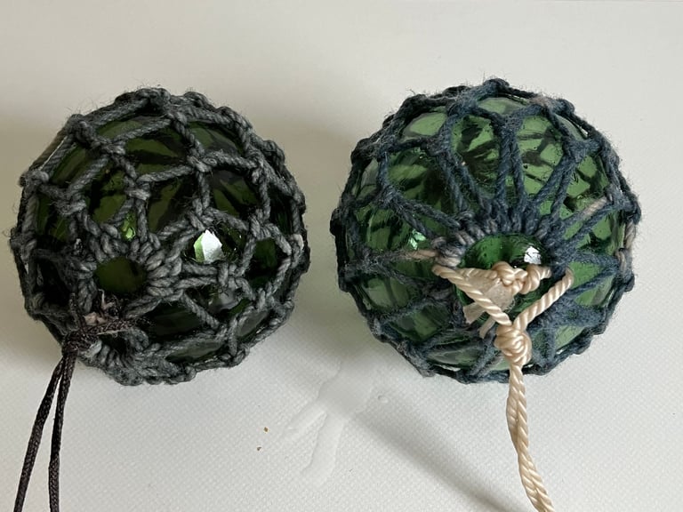 2 vintage green glass fishing floats in original string netting