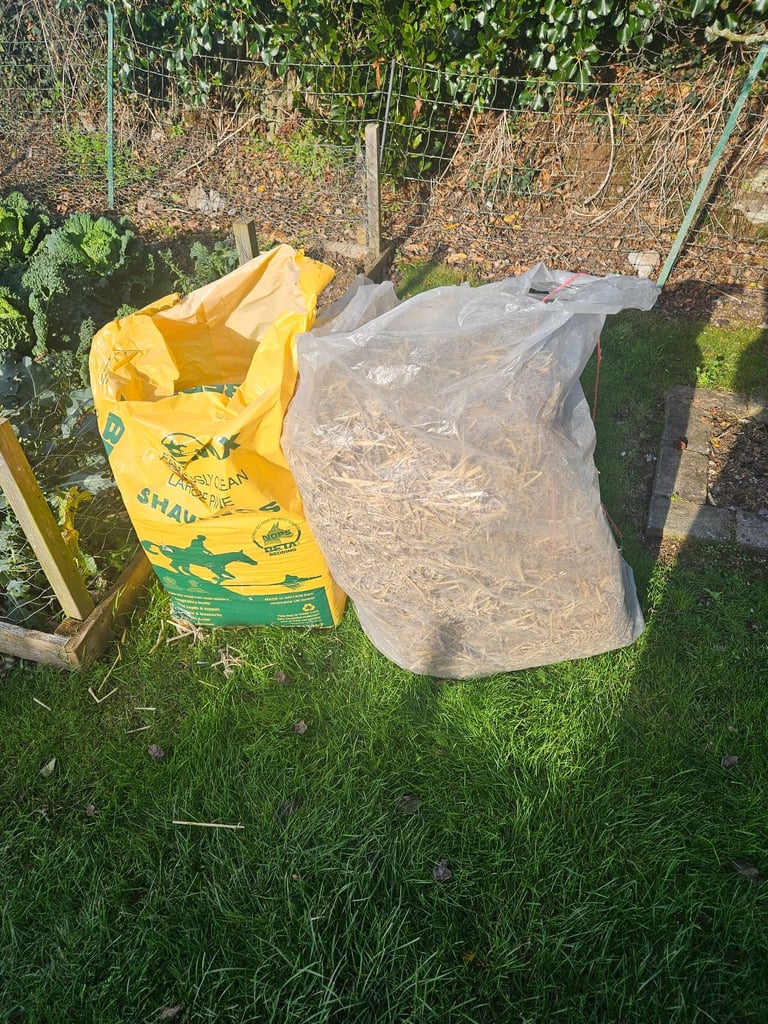 Wrapped bail of straw and course wood chippings chicken bedding 