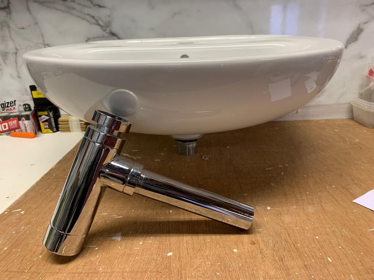 White ceramic sink with chrome waste pipe