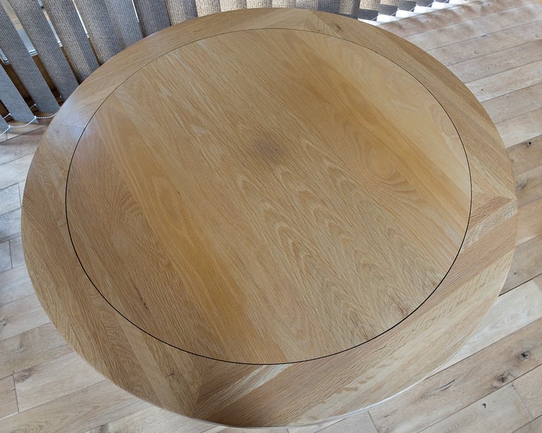 Solid oak circular dining table on a grey pedestal base
