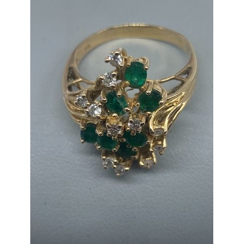 A 14ct yellow gold diamond & emerald dress ring