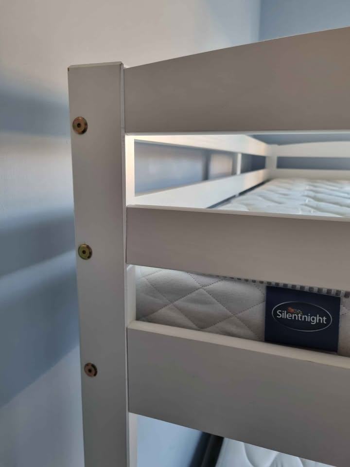 White wooden framed bunk beds with mattresses