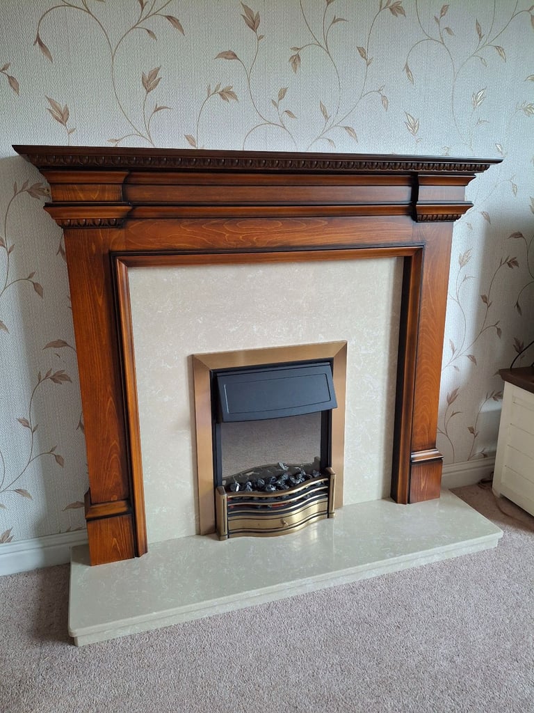 Modern fireplace set complete with wooden surround, marble hearth, and electric fire.