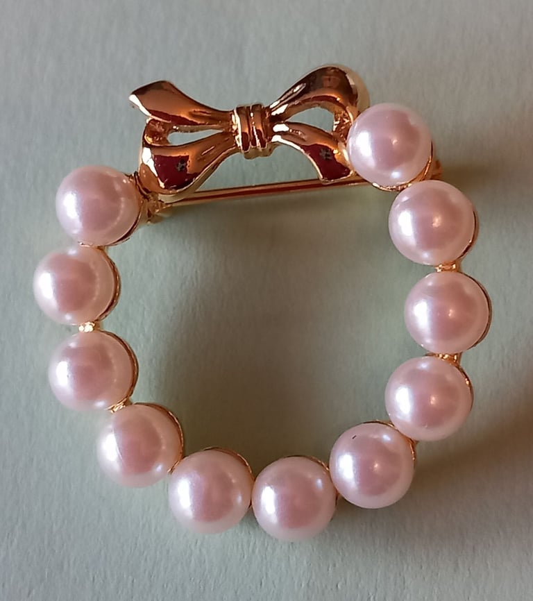 Ring of pearl like stones with gold coloured bow brooch, good gift idea