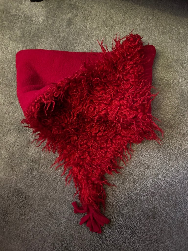 Red fuzzy fleece hat with tassels. .  