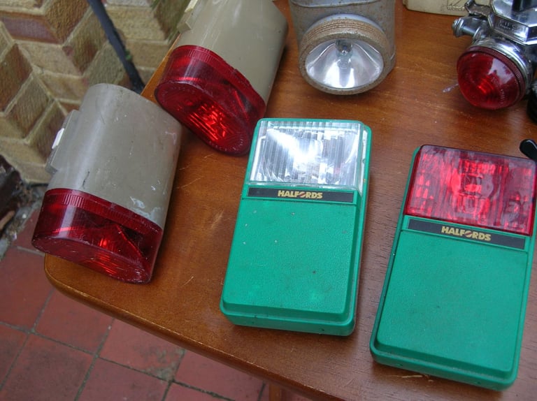 Collection of vintage front and rear bicycle lights.
