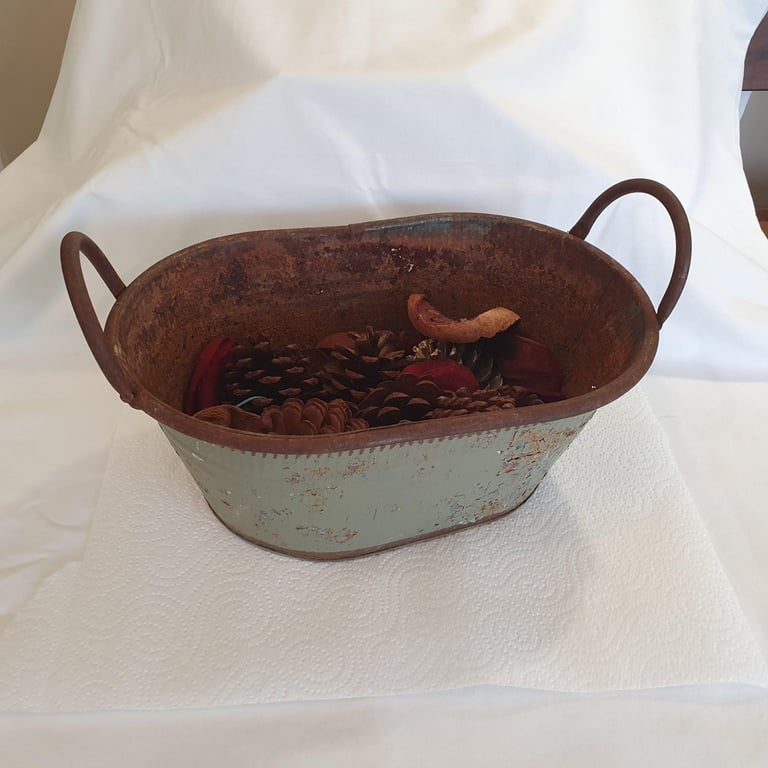 Rustic metal bath-shaped trough, including some pine cones and other Christmas decoration material