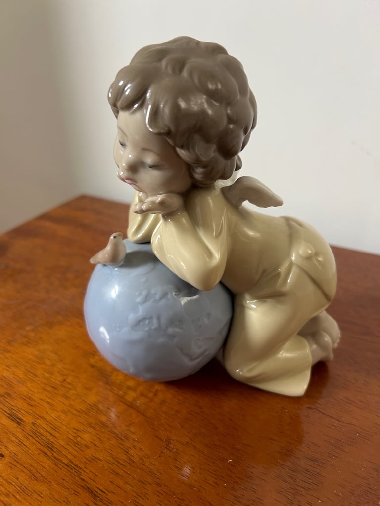 NAO by Lladro girl angel, leaning over a globe with bird