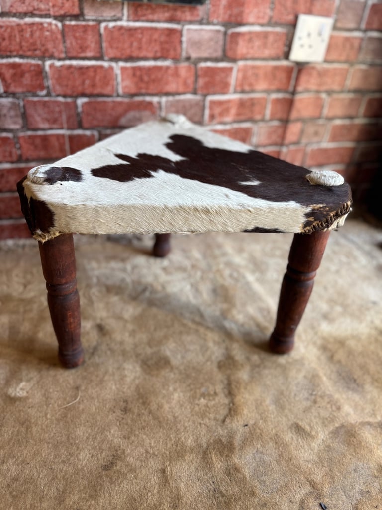 A Vintage Handmade 3 legged stool with cow hide seat.