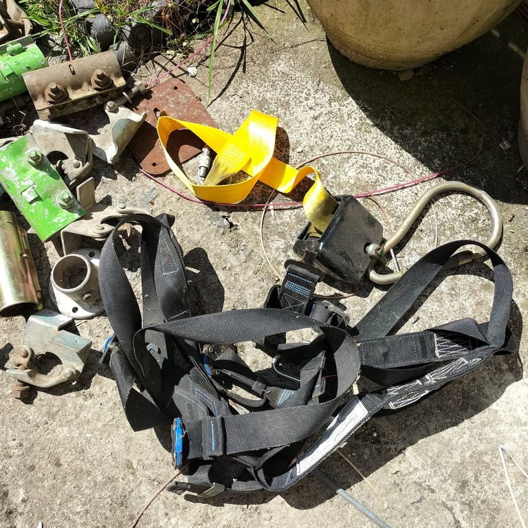 Scaffolding sleeve and board retaining clamps plus safety harness strap