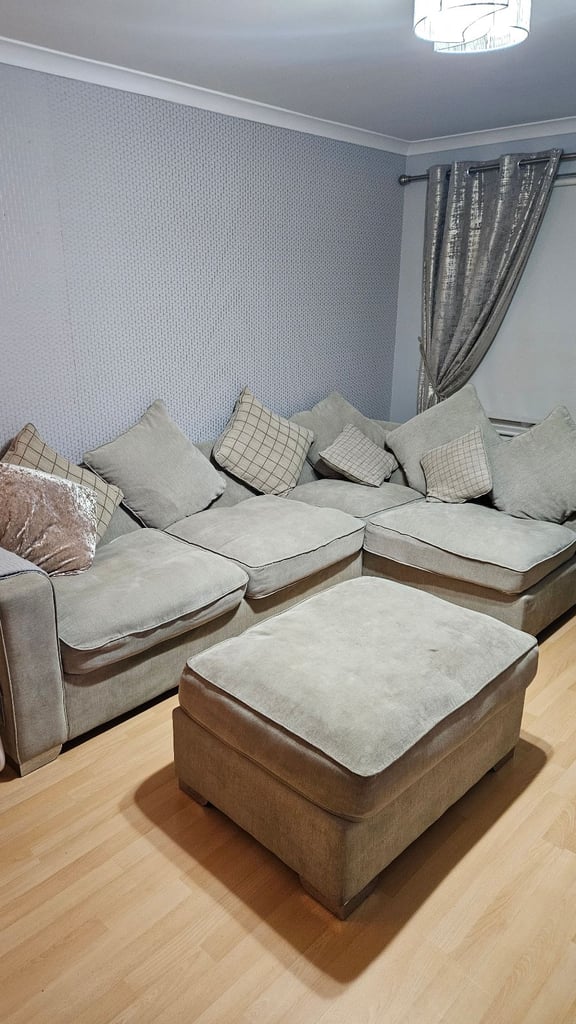 Grey fabric corner suite with chair, pouffe and cushions. 