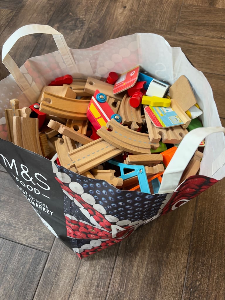 A bag full of wooden train track elements with many extras
