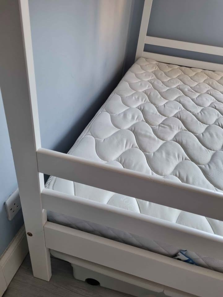 White wooden framed bunk beds with mattresses