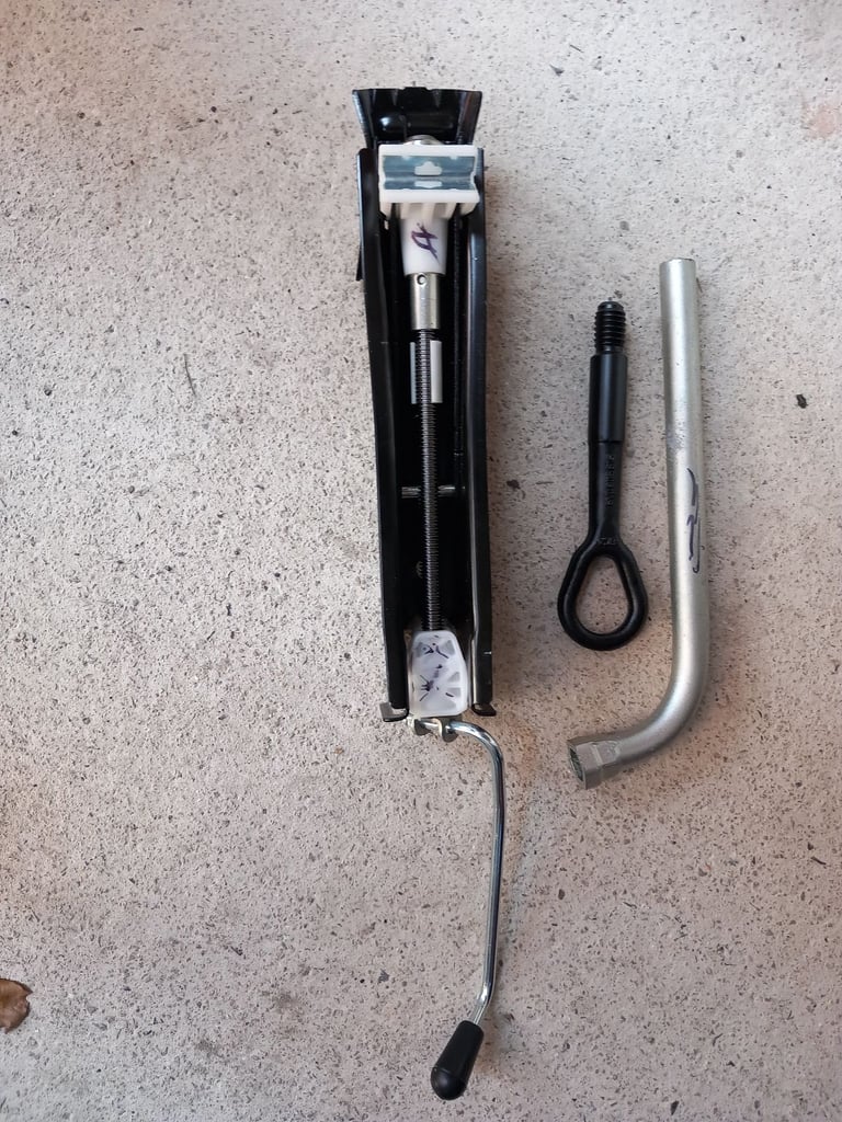 New car jack with wheel spanner and towing eye.