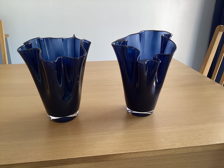A pair of blue glass flower vases. 