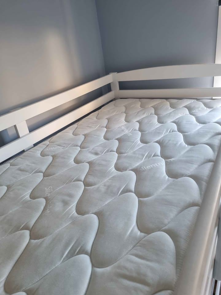 White wooden framed bunk beds with mattresses