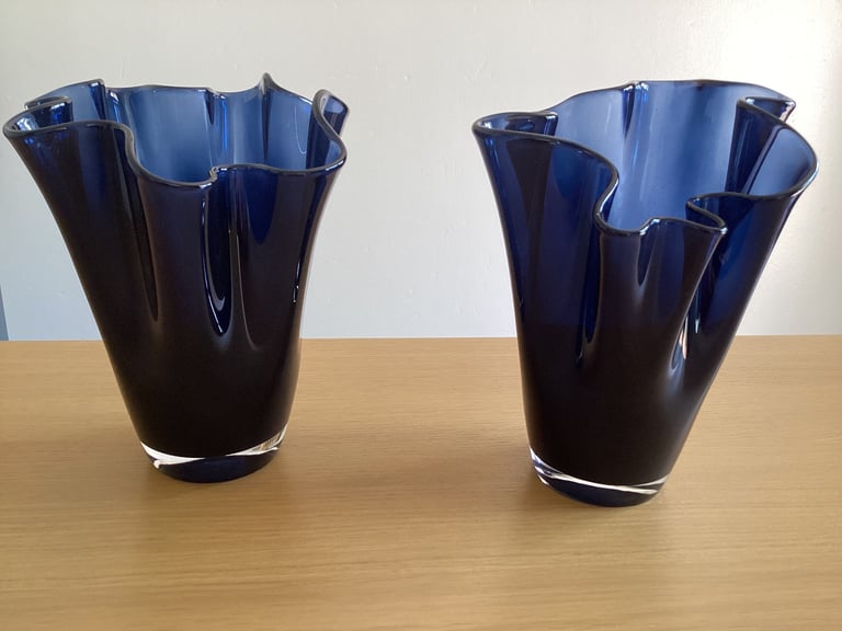 A pair of blue glass flower vases. 
