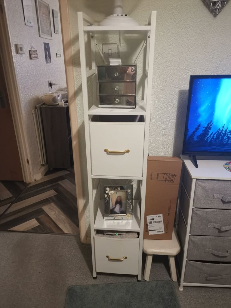 Elegant white slim shelving unit with storage boxes