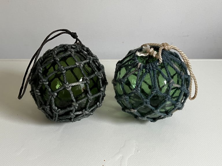 2 vintage green glass fishing floats in original string netting