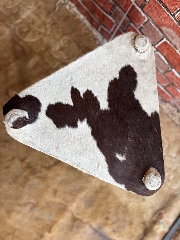 A Vintage Handmade 3 legged stool with cow hide seat.
