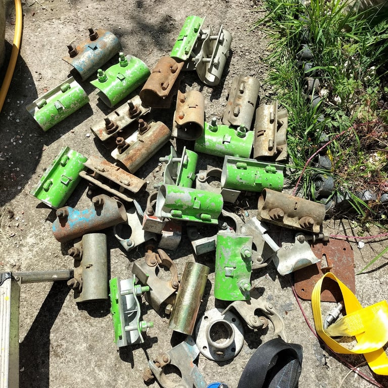 Scaffolding sleeve and board retaining clamps plus safety harness strap