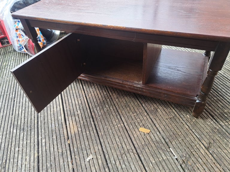 old dark wood tv stand with cupboard in the middle 