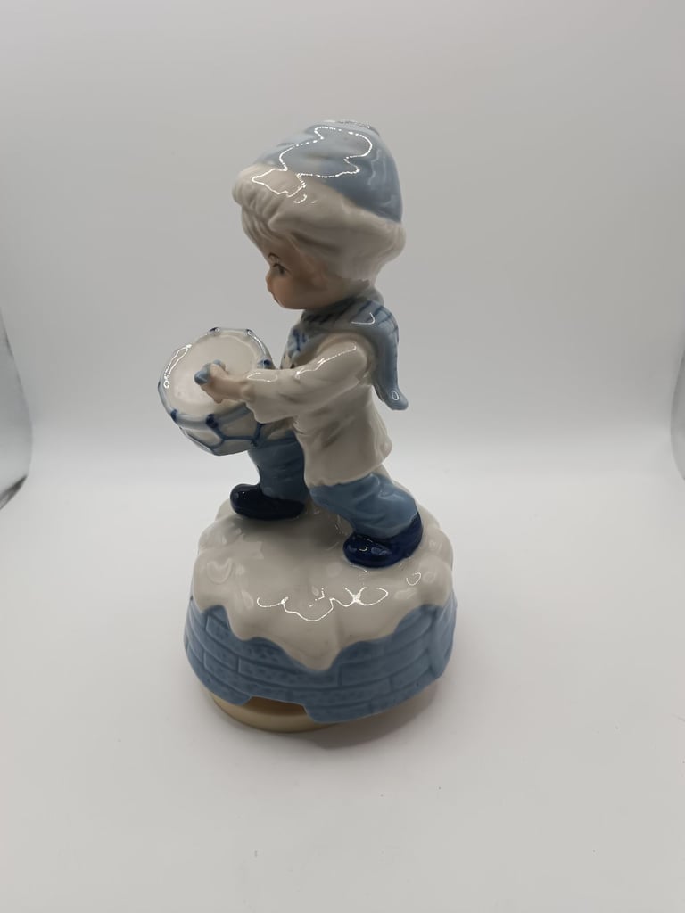 Vintage blue and white ceramic music drummer boy. Turns and music plays