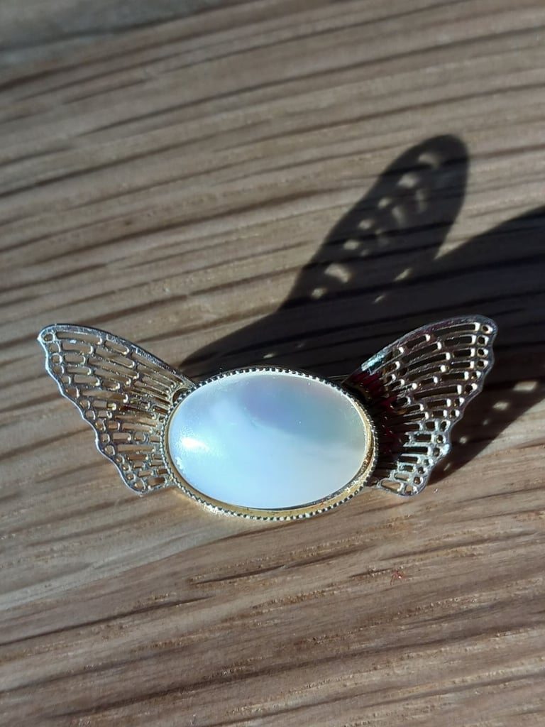 Filigree effect gold coloured Winged Brooch with white opalescent oval centre , lovely gift idea