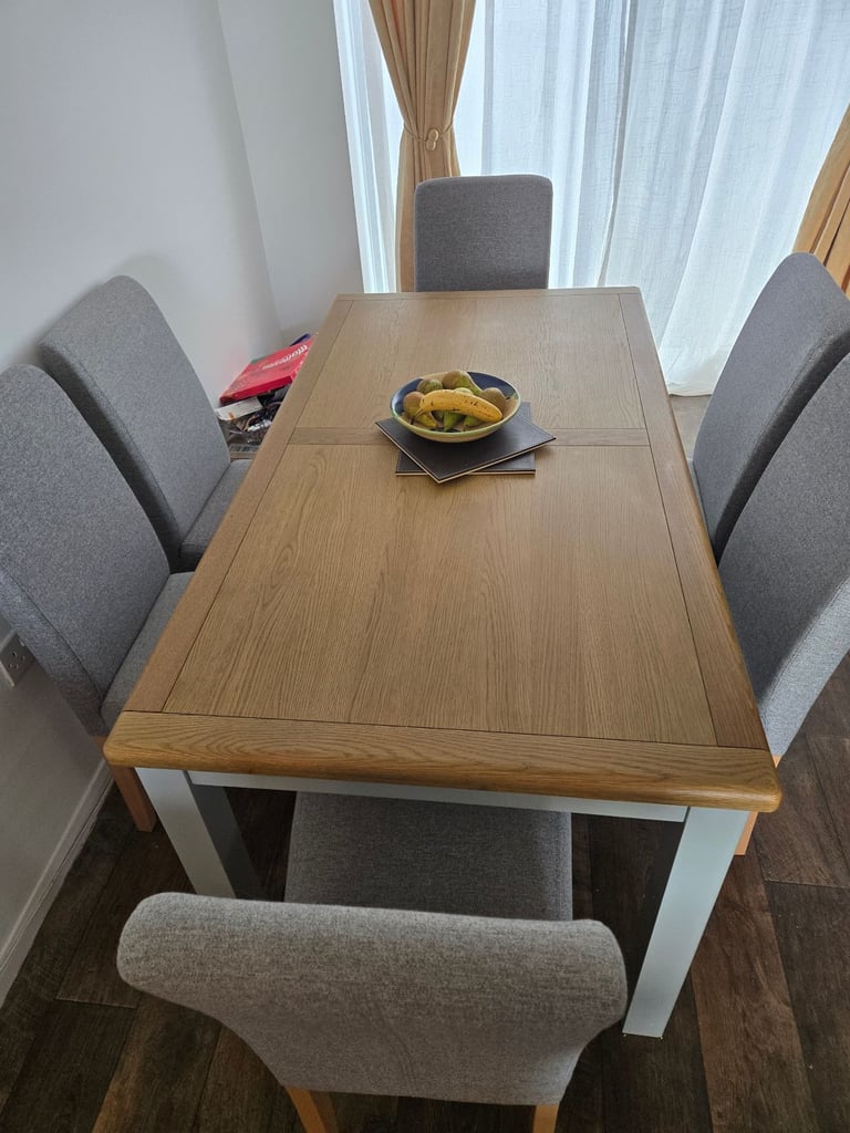 Solid oak dining table with 6 grey upholstered chairs 
