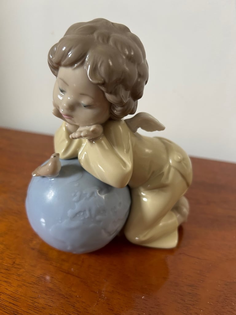 NAO by Lladro girl angel, leaning over a globe with bird