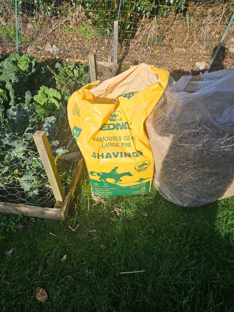 Wrapped bail of straw and course wood chippings chicken bedding 