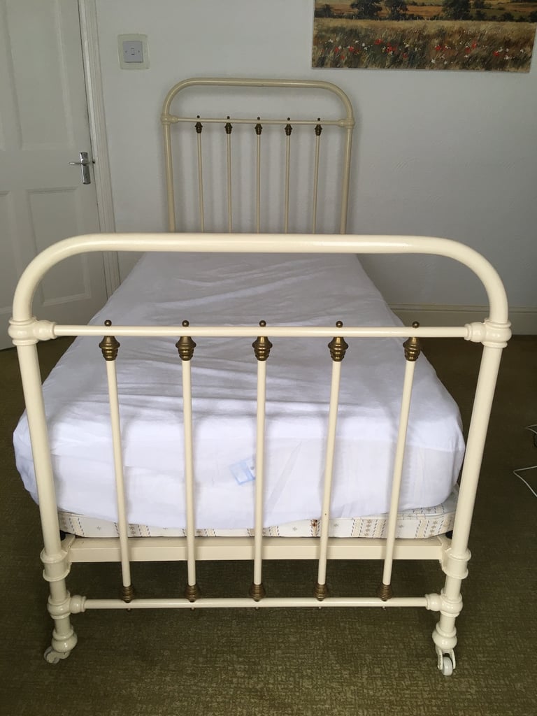 Vintage French brass & cream cast iron single bed on brass & china castors 