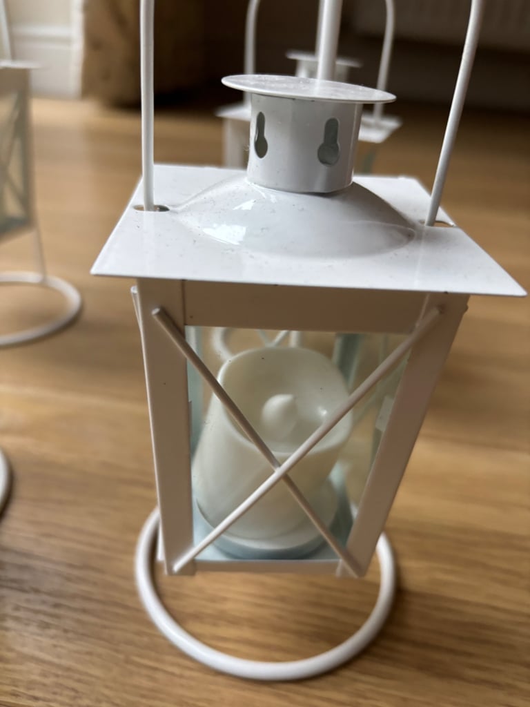Four small white metal tea light lanterns 
