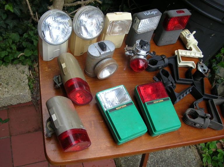 Collection of vintage front and rear bicycle lights.