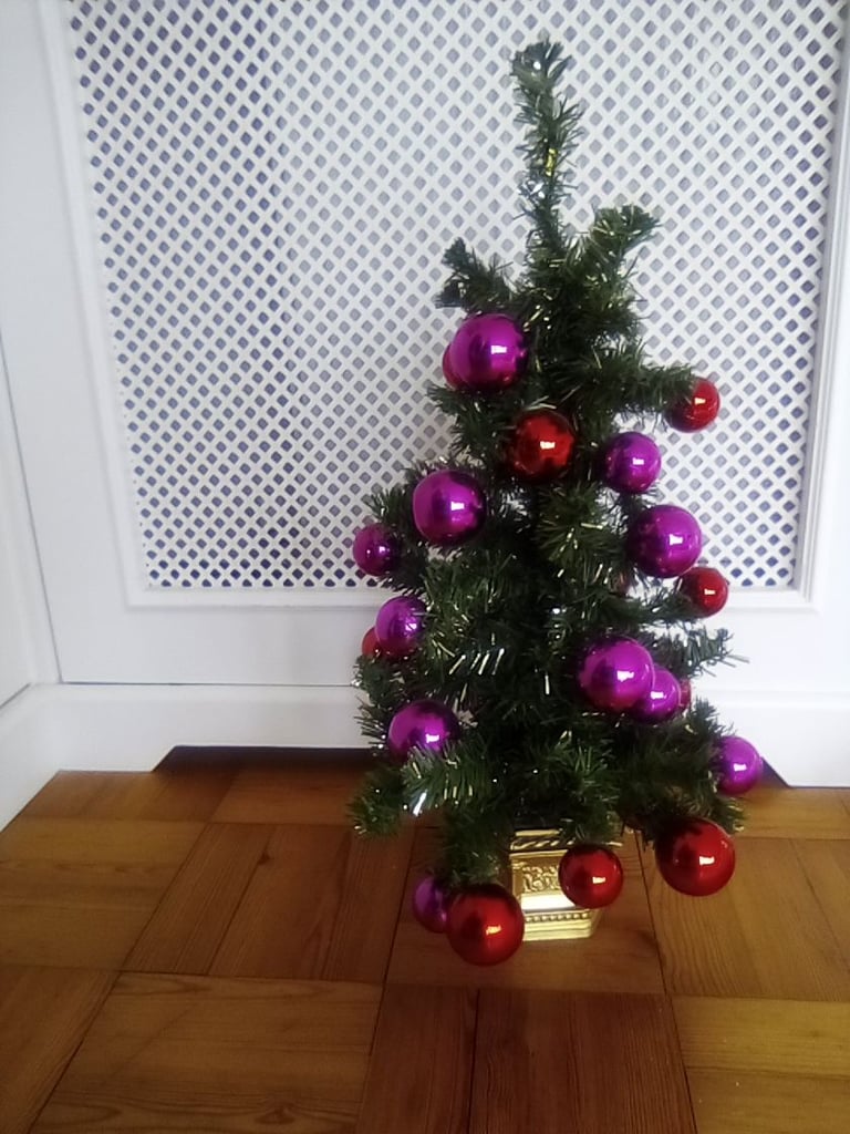 Small artificial Christmas tree, with bauble and other decorations.